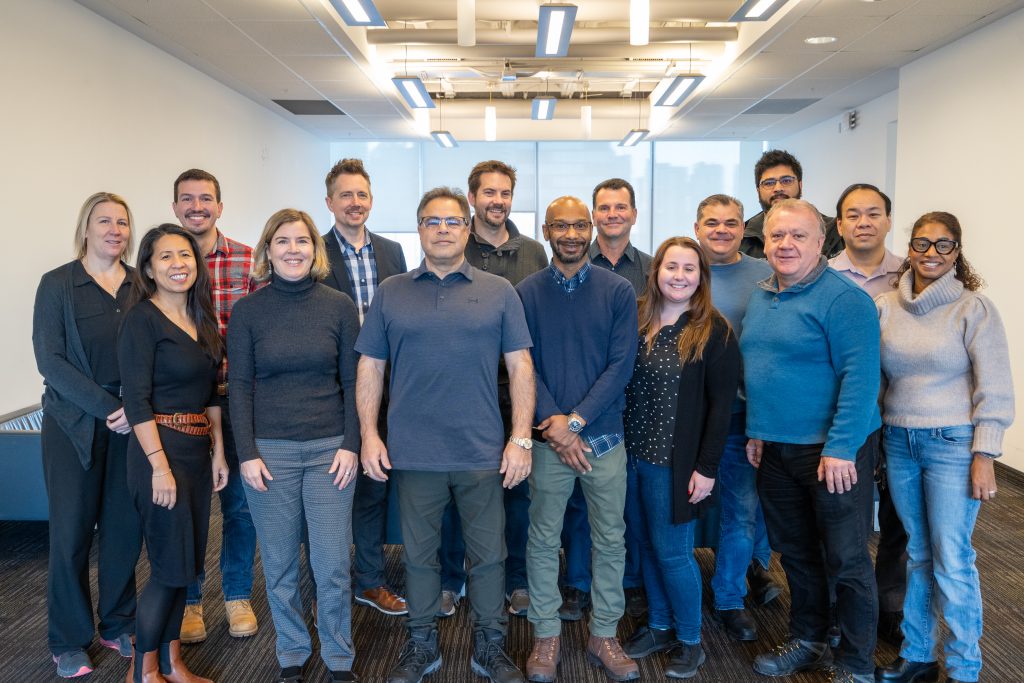A group of property managers poses for a team photo in a university building.
