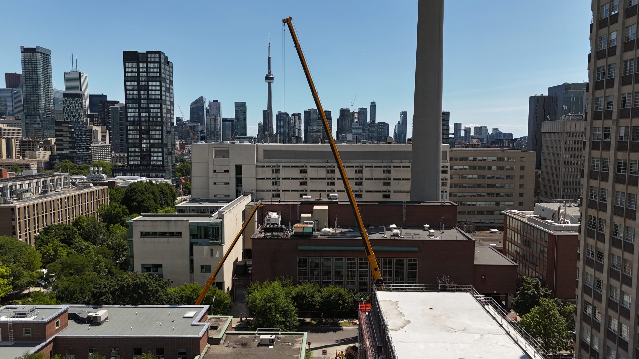 An aerial shot of the crane with the skyline of Toronto visible, including the CN Tower, behind it. 